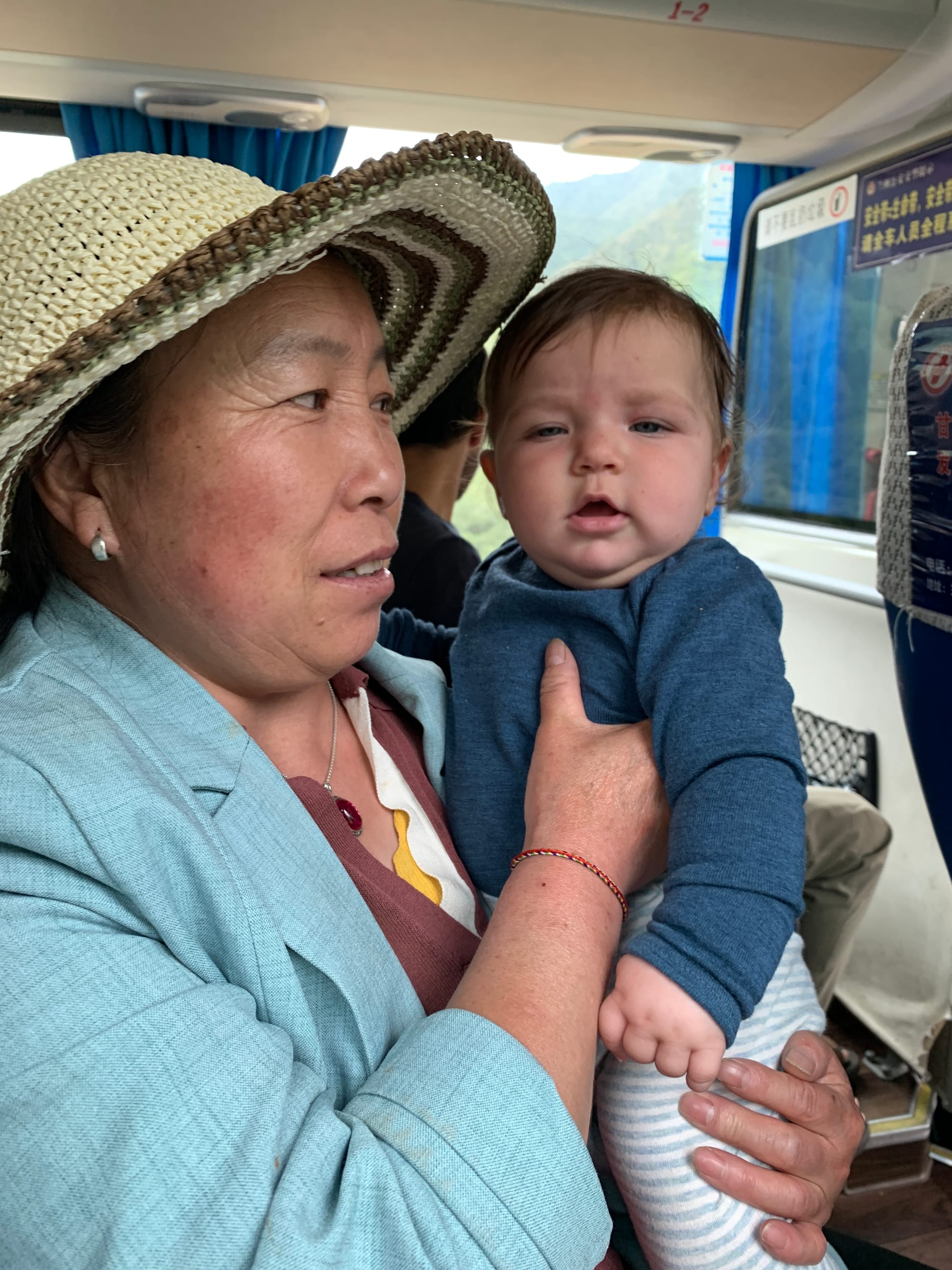 Nina held by a stranger on the bus in China